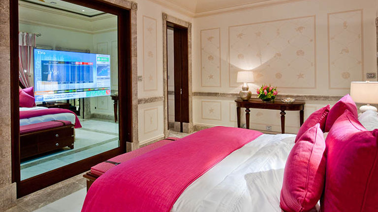 A television is built into the sliding door that separates the bedroom from the living room in suites. // © 2017 The Pink Sands Club