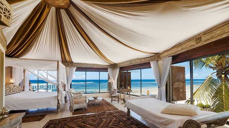 The master bedroom on the top floor of the Cliff Villa includes handcrafted furniture and stunning panoramic views. // © 2016 Alfajiri Villas